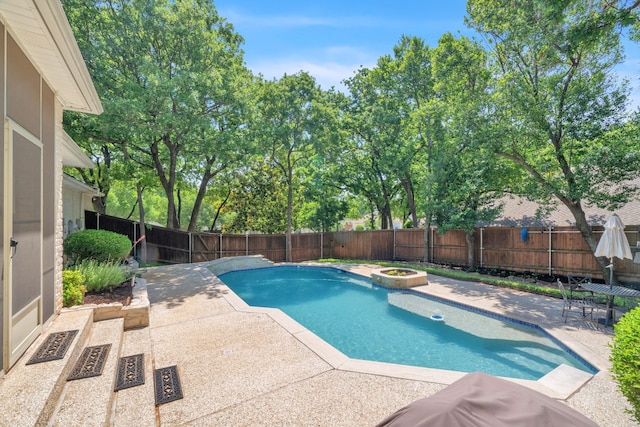 view of swimming pool featuring a patio area, a fenced backyard, and a pool with connected hot tub