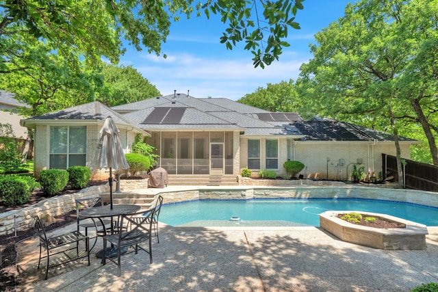 outdoor pool featuring a sunroom and a patio area