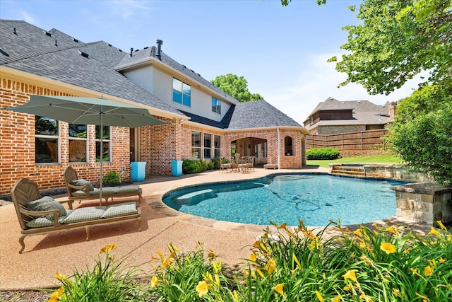 view of swimming pool featuring a patio area, fence, and an in-ground hot tub