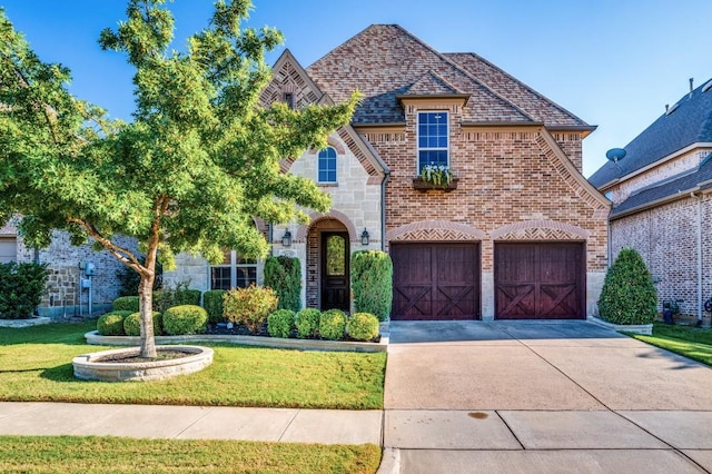 3020 Speyburn, The Colony, TX 75056 - french country home featuring stone siding, a front lawn, brick siding, and concrete driveway