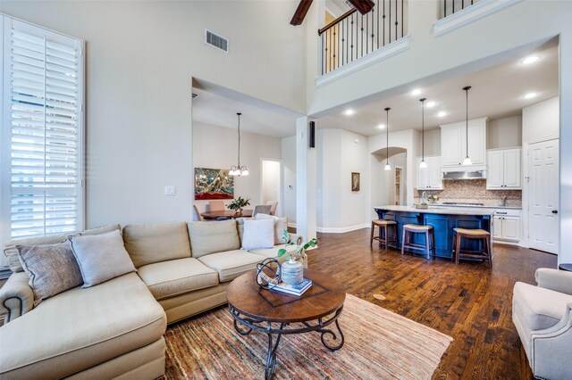 3020 Speyburn, The Colony, TX 75056 - living room featuring dark wood finished floors, a towering ceiling, a chandelier, and baseboards