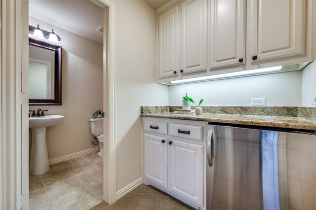 3020 Speyburn, The Colony, TX 75056 - kitchen featuring white cabinetry, light stone counters, baseboards, and a sink