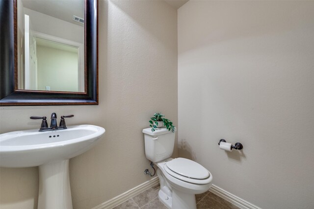 3020 Speyburn, The Colony, TX 75056 - half bath with toilet, baseboards, tile patterned floors, and a sink