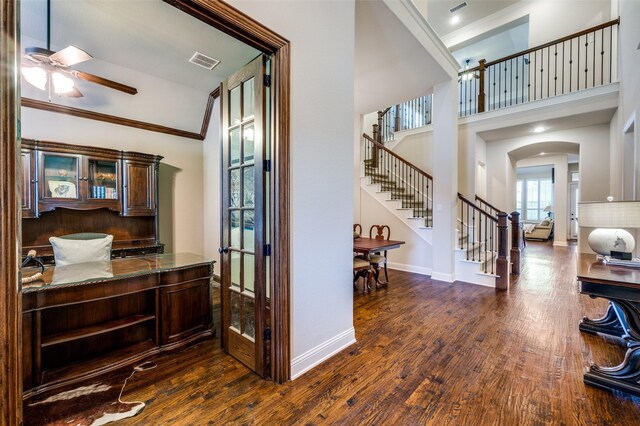 3020 Speyburn, The Colony, TX 75056 - bar area featuring a ceiling fan, stairs, dark wood-style floors, arched walkways, and a towering ceiling