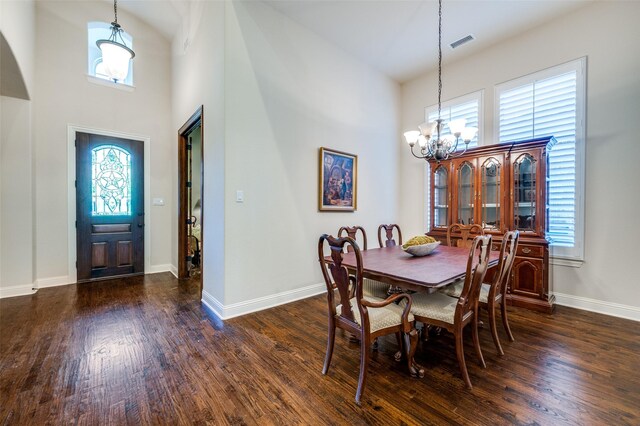 3020 Speyburn, The Colony, TX 75056 - dining area with a chandelier, dark wood-type flooring, a towering ceiling, and baseboards