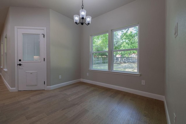 914 S Brazos St, Weatherford, TX 76086 - unfurnished dining area with wood finished floors, a chandelier, and baseboards