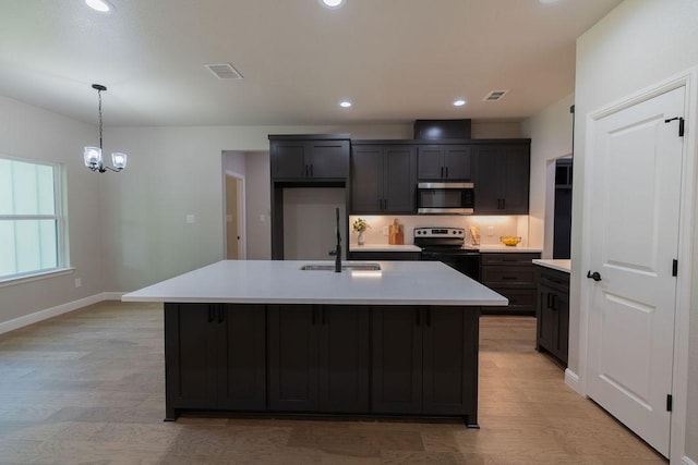 914 S Brazos St, Weatherford, TX 76086 - kitchen featuring appliances with stainless steel finishes, a sink, light wood-style flooring, light countertops, and recessed lighting