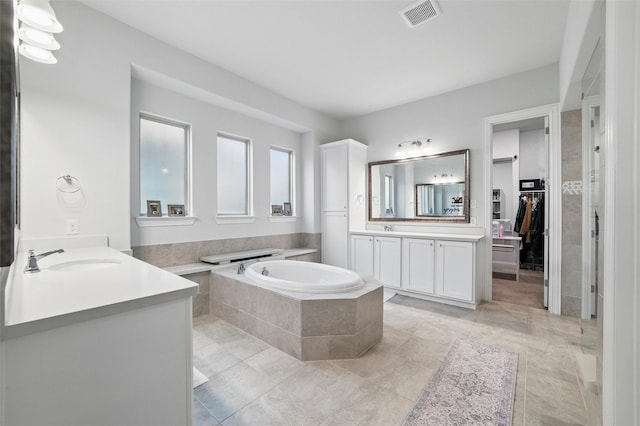 1105 Collared Dove Dr, Little Elm, TX 75068 - full bath featuring two vanities, a garden tub, a walk in closet, and tile patterned flooring