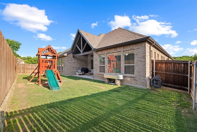 1105 Collared Dove Dr, Little Elm, TX 75068 - back of property featuring a playground, brick siding, roof with shingles, and a patio area