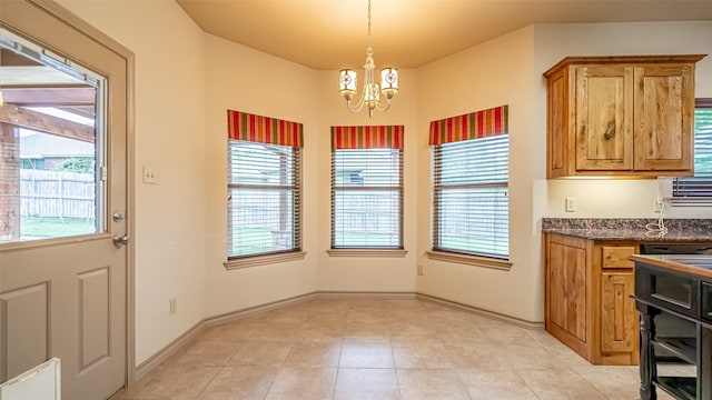 810 Prairie Wind Blvd, Stephenville, TX 76401 - unfurnished dining area featuring a chandelier, light tile patterned floors, and baseboards