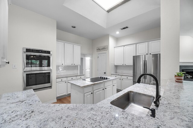 117 Clipper Ct, Rockwall, TX 75032 - kitchen with stainless steel appliances, a sink, white cabinetry, and recessed lighting