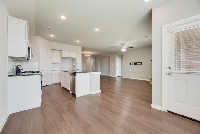 2122 Slow Stream Dr, Royse City, TX 75189 - kitchen with appliances with stainless steel finishes, a ceiling fan, open floor plan, white cabinets, and a center island with sink