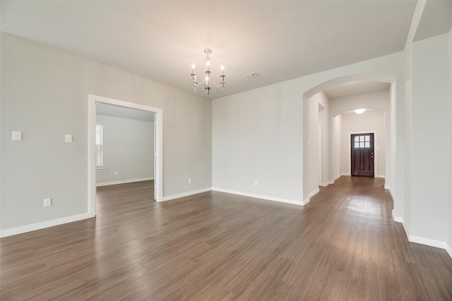 2122 Slow Stream Dr, Royse City, TX 75189 - unfurnished room featuring arched walkways, a chandelier, dark wood-type flooring, and baseboards