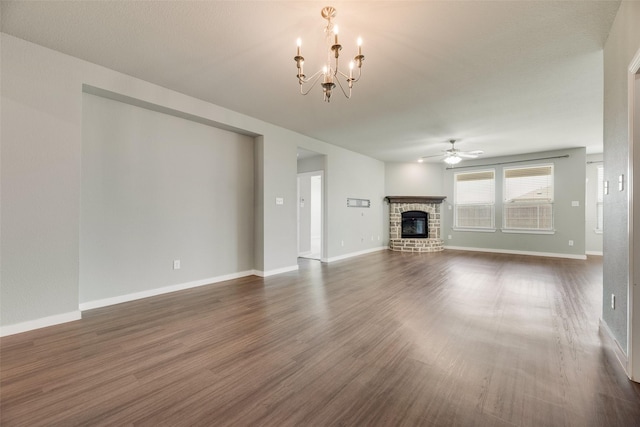 2122 Slow Stream Dr, Royse City, TX 75189 - unfurnished living room featuring a brick fireplace, ceiling fan, dark wood finished floors, a chandelier, and baseboards