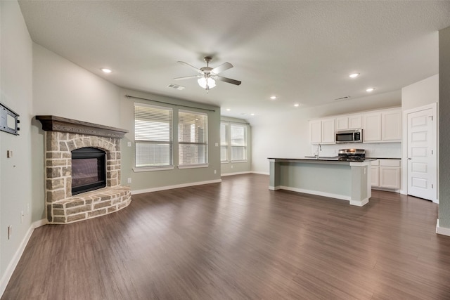 2122 Slow Stream Dr, Royse City, TX 75189 - unfurnished living room featuring a ceiling fan, dark wood-type flooring, a fireplace, baseboards, and recessed lighting