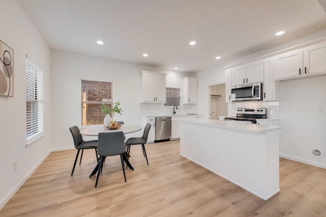 3732 Venera St, Fort Worth, TX 76106 - kitchen featuring appliances with stainless steel finishes, white cabinetry, light countertops, a sink, and light wood-type flooring