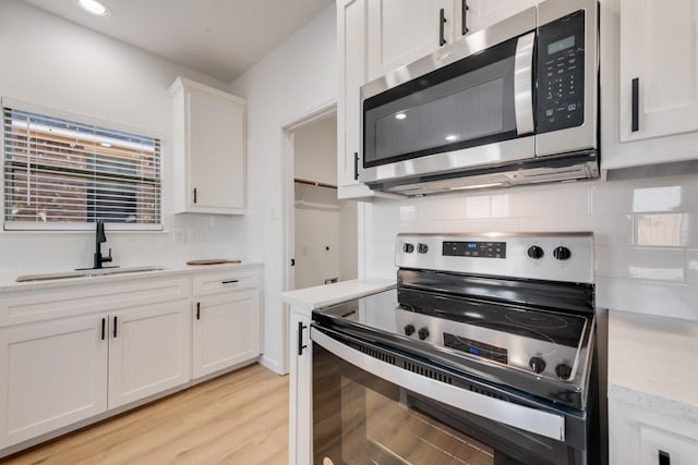 3732 Venera St, Fort Worth, TX 76106 - kitchen with appliances with stainless steel finishes, a sink, tasteful backsplash, and white cabinetry