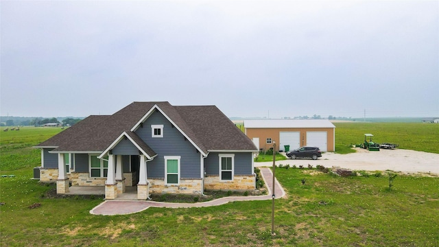 397 Hcr 2341, Abbott, TX 76621 - view of front of property featuring stone siding, a detached garage, a front yard, roof with shingles, and covered porch