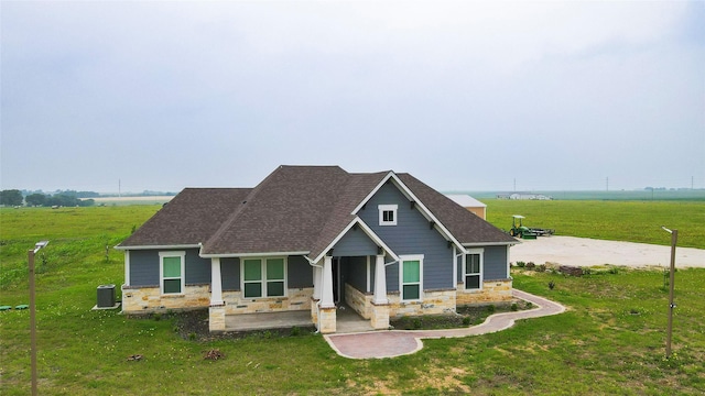 397 Hcr 2341, Abbott, TX 76621 - view of front of property with stone siding, a front lawn, roof with shingles, and central AC unit