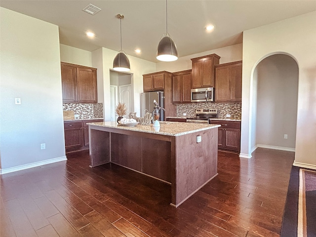 397 Hcr 2341, Abbott, TX 76621 - kitchen featuring stainless steel appliances, arched walkways, a center island with sink, decorative backsplash, and dark wood-style flooring
