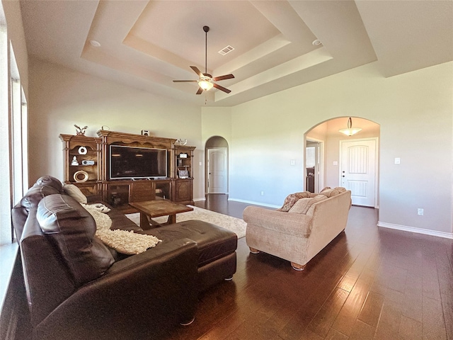 397 Hcr 2341, Abbott, TX 76621 - living room featuring arched walkways, a tray ceiling, ceiling fan, dark wood-type flooring, and baseboards