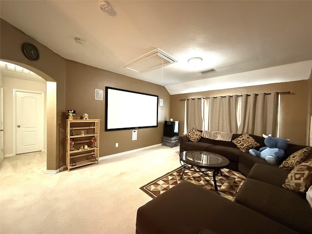 8608 Davis Dr, Frisco, TX 75036 - home theater room with light carpet, baseboards, lofted ceiling, and arched walkways