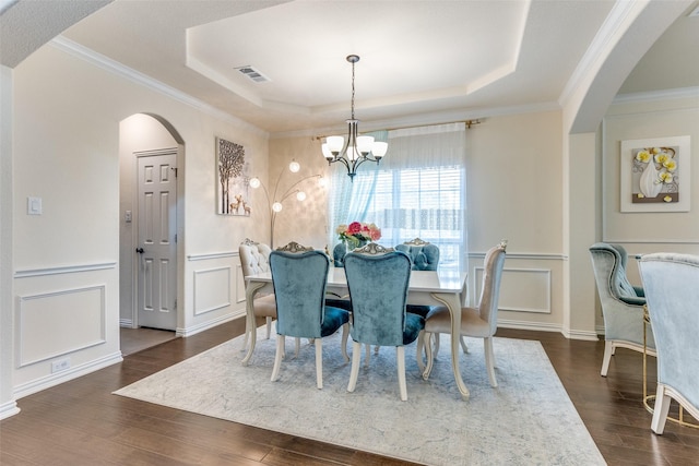 1324 Needle Cactus Dr, Fort Worth, TX 76177 - dining area with arched walkways, a tray ceiling, a decorative wall, a chandelier, and dark wood finished floors