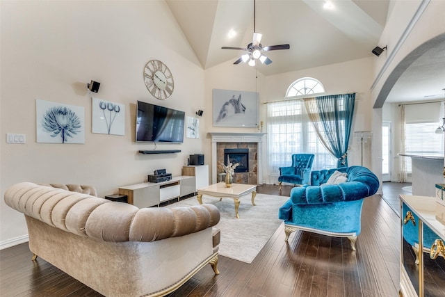 1324 Needle Cactus Dr, Fort Worth, TX 76177 - living room with arched walkways, ceiling fan, a tiled fireplace, high vaulted ceiling, and dark wood-style flooring