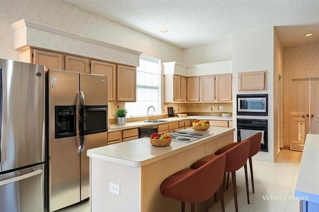 1325 Bentley Dr, Carrollton, TX 75006 - kitchen with stainless steel appliances, a sink, wallpapered walls, a kitchen island, and light countertops