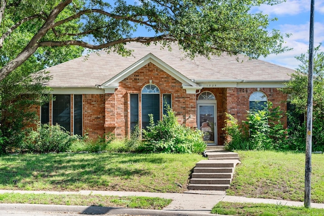 1325 Bentley Dr, Carrollton, TX 75006 - view of front of home with a front lawn, brick siding, and roof with shingles
