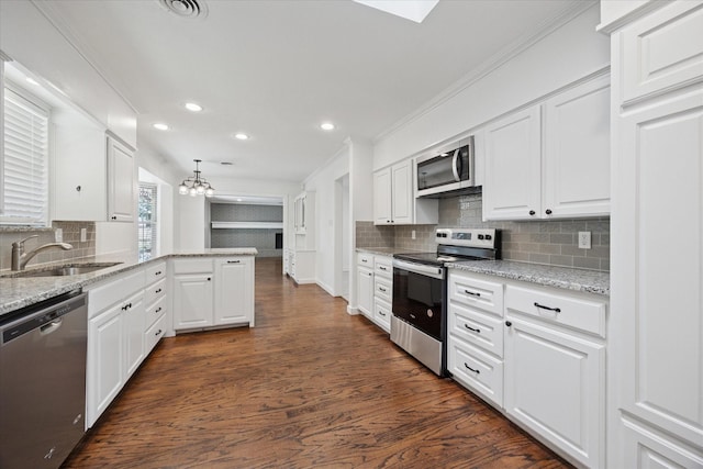 3211 Darby Ln, Denton, TX 76207 - kitchen with appliances with stainless steel finishes, a sink, ornamental molding, recessed lighting, and white cabinetry