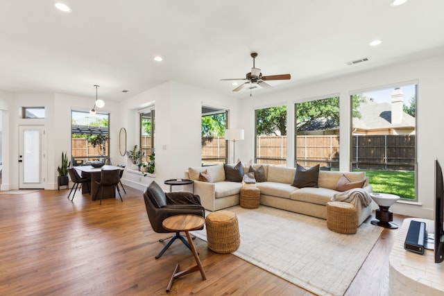 living area with wood finished floors, recessed lighting, a ceiling fan, and baseboards