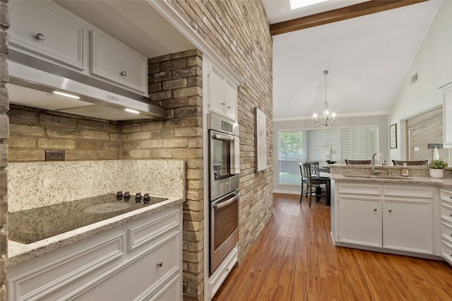 7624 Kevin Dr, Dallas, TX 75248 - kitchen featuring a sink, double oven, under cabinet range hood, white cabinetry, and black electric cooktop