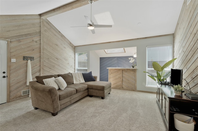 7624 Kevin Dr, Dallas, TX 75248 - carpeted living room with wooden walls, a skylight, lofted ceiling, and a ceiling fan