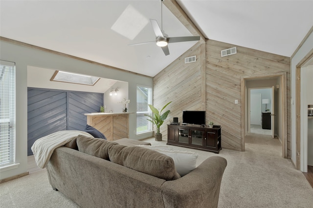 7624 Kevin Dr, Dallas, TX 75248 - living room featuring a skylight, wood walls, lofted ceiling, ceiling fan, and carpet floors