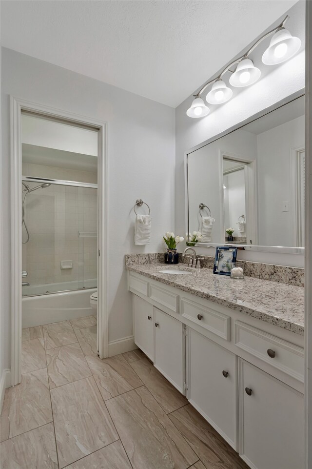 7624 Kevin Dr, Dallas, TX 75248 - full bath with vanity, toilet, marble finish floors, enclosed tub / shower combo, and baseboards