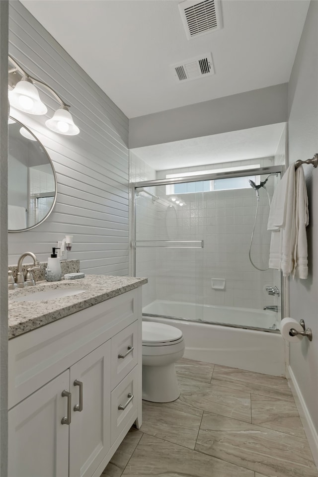 7624 Kevin Dr, Dallas, TX 75248 - full bathroom with vanity, toilet, bath / shower combo with glass door, and marble look tile flooring