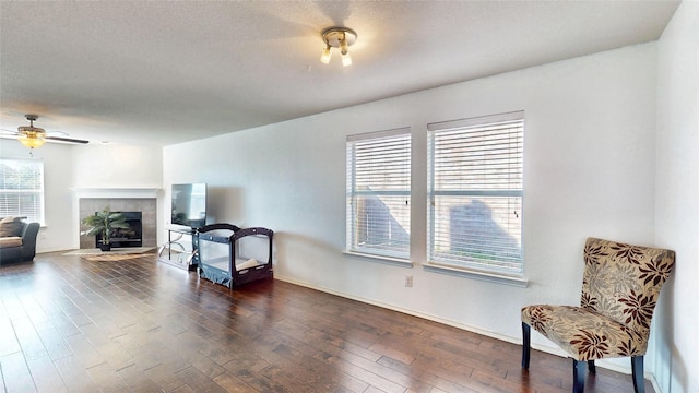 2225 Marion Dr, Mckinney, TX 75072 - sitting room with dark wood-type flooring, ceiling fan, a tiled fireplace, and baseboards