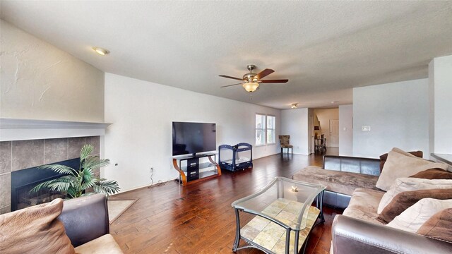 2225 Marion Dr, Mckinney, TX 75072 - living room with a ceiling fan, dark wood-style floors, a fireplace, and a textured ceiling