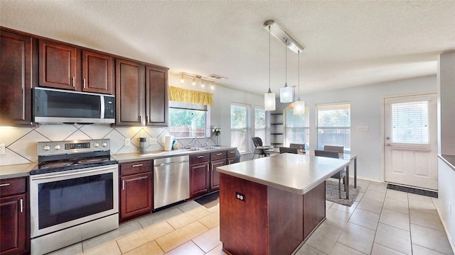 2225 Marion Dr, Mckinney, TX 75072 - kitchen featuring stainless steel appliances, backsplash, a sink, light countertops, and healthy amount of natural light