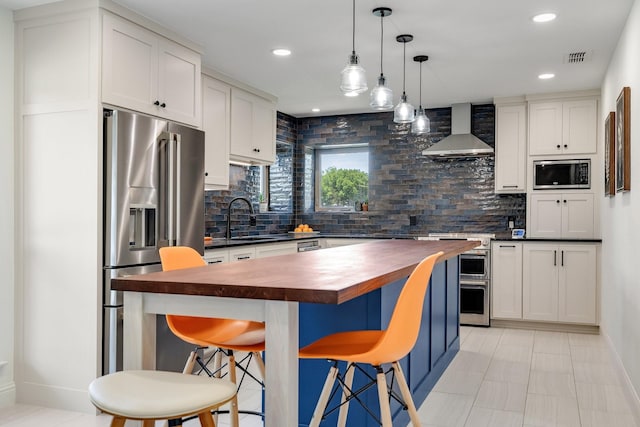 941 Mccampbell Rd, Mansfield, TX 76063 - kitchen with wooden counters, wall chimney exhaust hood, high end appliances, a sink, and backsplash