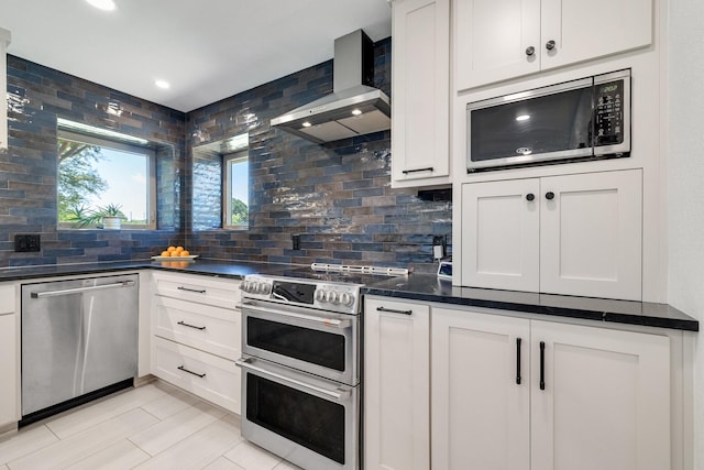 941 Mccampbell Rd, Mansfield, TX 76063 - kitchen featuring appliances with stainless steel finishes, wall chimney range hood, dark countertops, backsplash, and white cabinets