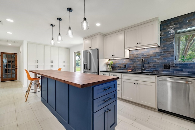 941 Mccampbell Rd, Mansfield, TX 76063 - kitchen with butcher block countertops, stainless steel appliances, a sink, backsplash, and white cabinets