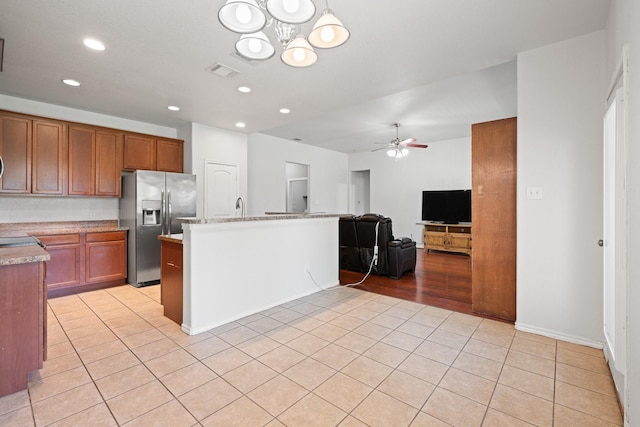 303 Stonegate Blvd, Alvarado, TX 76009 - kitchen featuring stainless steel refrigerator with ice dispenser, light tile patterned floors, a ceiling fan, recessed lighting, and a chandelier
