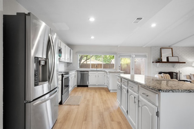 kitchen with appliances with stainless steel finishes, light wood-style floors, tasteful backsplash, white cabinetry, and recessed lighting