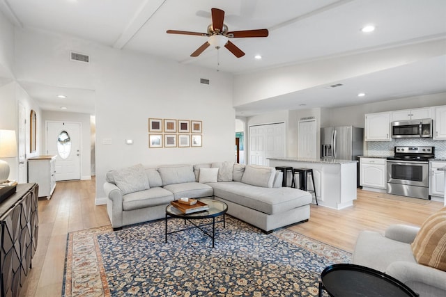living room featuring light wood-style flooring, a ceiling fan, and recessed lighting