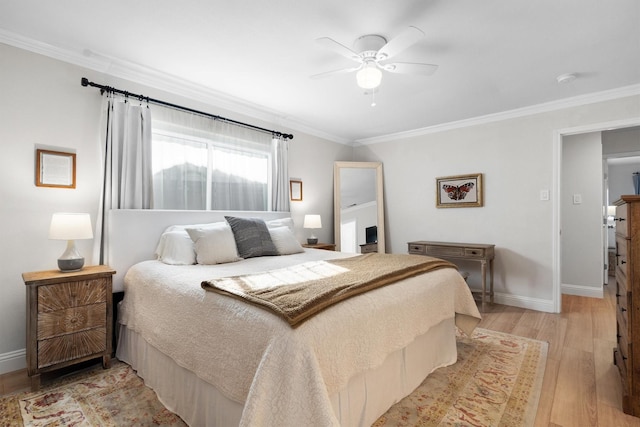 bedroom featuring crown molding, baseboards, light wood-style flooring, and ceiling fan