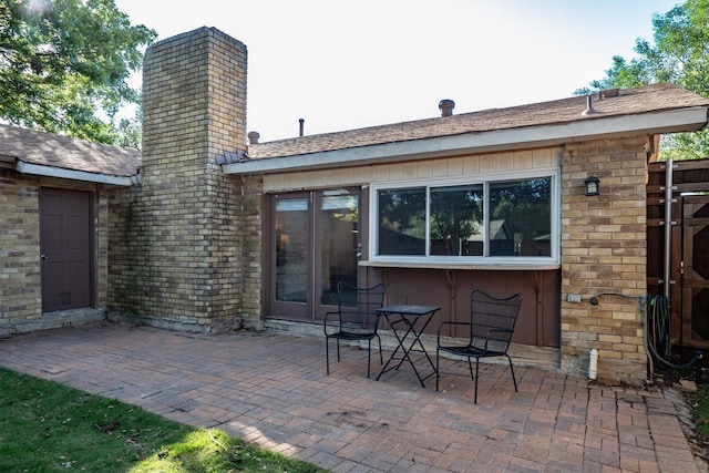 rear view of property featuring a patio area and a chimney