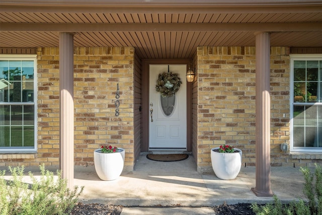 view of exterior entry featuring brick siding