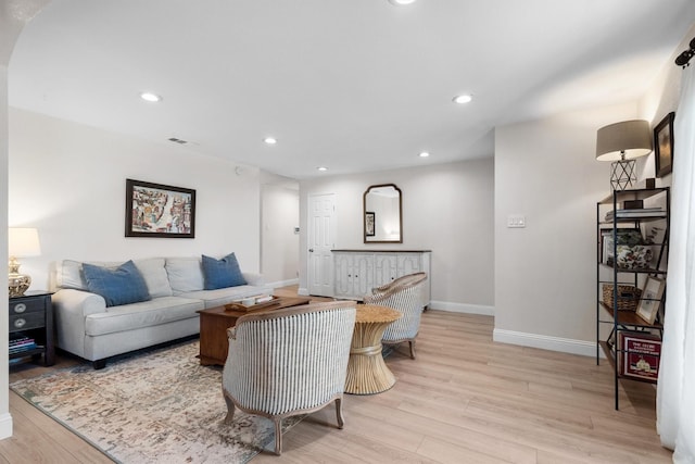 living area with baseboards, light wood-style flooring, and recessed lighting